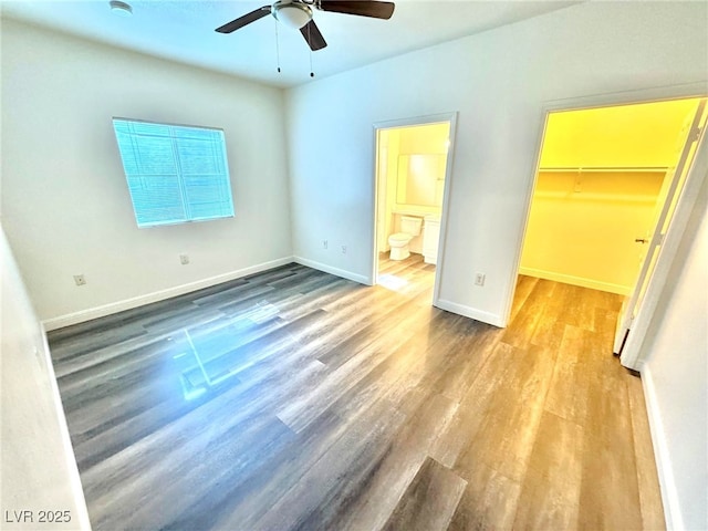 5250 S Rainbow Blvd Unit 2029, Las Vegas, NV 89118 - unfurnished bedroom with wood finished floors, a spacious closet, ensuite bathroom, baseboards, and a closet