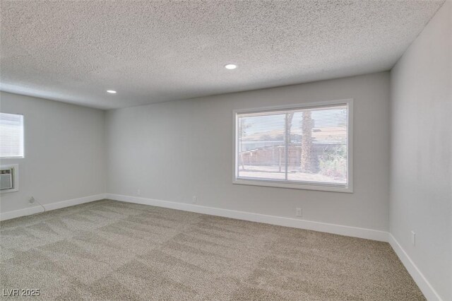 1825 Howard Ave, Las Vegas, NV 89104 - spare room featuring light carpet, a textured ceiling, recessed lighting, baseboards, and a wall mounted air conditioner