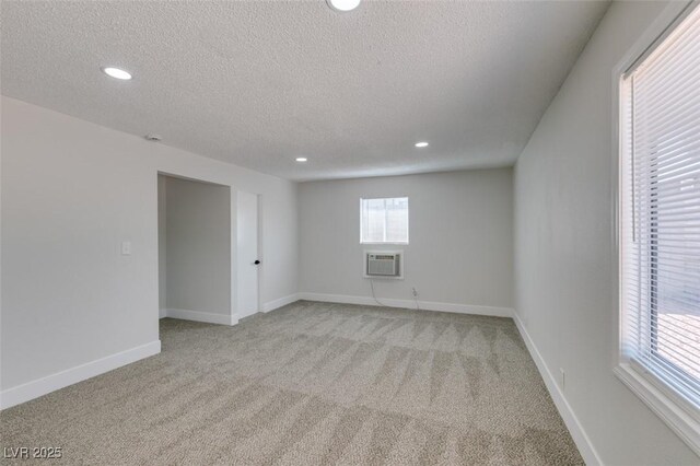 1825 Howard Ave, Las Vegas, NV 89104 - spare room featuring a textured ceiling, light carpet, a wall unit AC, recessed lighting, and baseboards