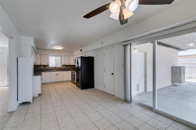 1806 Renada Cir, North Las Vegas, NV 89030 - kitchen featuring freestanding refrigerator, dark countertops, white cabinetry, tasteful backsplash, and a ceiling fan