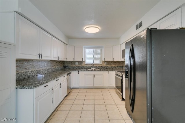 1806 Renada Cir, North Las Vegas, NV 89030 - kitchen featuring appliances with stainless steel finishes, a sink, white cabinets, backsplash, and light tile patterned floors