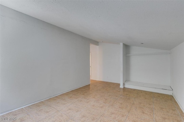 1806 Renada Cir, North Las Vegas, NV 89030 - empty room with a textured ceiling, lofted ceiling, and light tile patterned floors