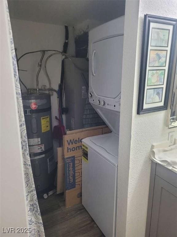 5335 Rod Ct Unit 102, Las Vegas, NV 89122 - washroom with water heater, estacked washer and dryer, dark wood-style flooring, and a textured wall