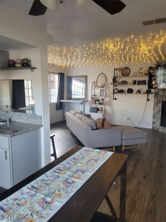 5335 Rod Ct Unit 102, Las Vegas, NV 89122 - living area featuring ceiling fan, wood finished floors, and a stone fireplace
