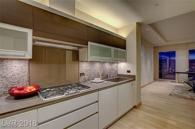 3750 S Las Vegas Blvd Unit 3111, Las Vegas, NV 89158 - kitchen featuring a sink, stainless steel gas cooktop, light wood-type flooring, white cabinetry, and tasteful backsplash