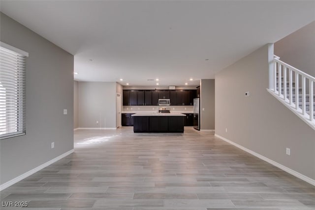 9239 Albus Hills Ave, Las Vegas, NV 89143 - kitchen with stainless steel appliances, open floor plan, light countertops, light wood-type flooring, and baseboards
