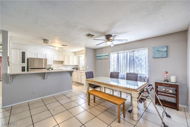 844 Balzar Ave, Las Vegas, NV 89106 - dining area with baseboards, a ceiling fan, a textured ceiling, and light tile patterned flooring