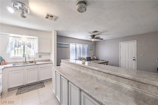 844 Balzar Ave, Las Vegas, NV 89106 - kitchen featuring a sink, white cabinets, light countertops, light tile patterned flooring, and ceiling fan