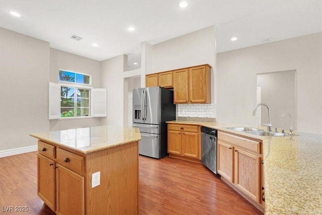 1212 E Rome Blvd, North Las Vegas, NV 89086 - kitchen featuring stainless steel appliances, a sink, light wood finished floors, decorative backsplash, and recessed lighting
