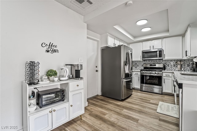 2507 Albemarle Way, Henderson, NV 89014 - kitchen with appliances with stainless steel finishes, light countertops, white cabinetry, backsplash, and light wood-style floors