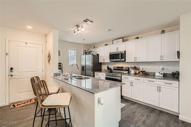 6835 Orange Horizon St, North Las Vegas, NV 89086 - kitchen with stainless steel appliances, a sink, a breakfast bar, and dark wood-style flooring