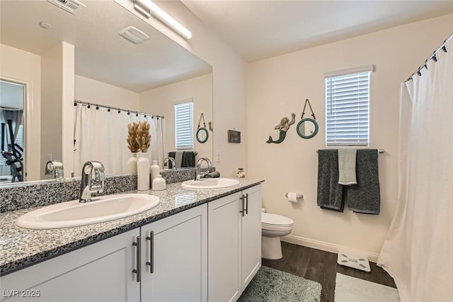 6835 Orange Horizon St, North Las Vegas, NV 89086 - bathroom with toilet, wood finished floors, double vanity, and baseboards