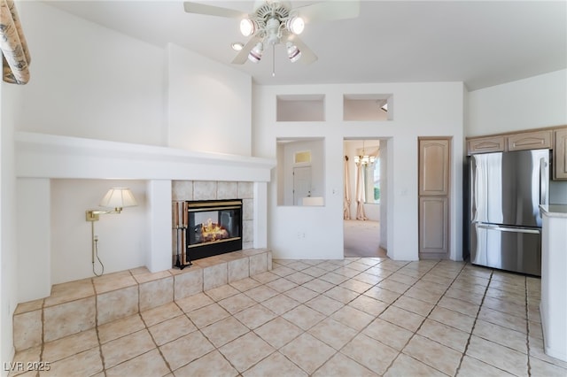 9812 Folsom Dr, Las Vegas, NV 89134 - unfurnished living room with ceiling fan, light tile patterned flooring, a tiled fireplace, and a chandelier