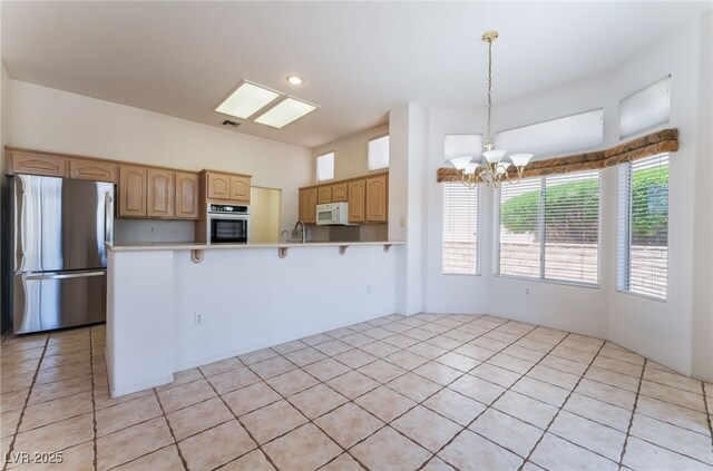 9812 Folsom Dr, Las Vegas, NV 89134 - kitchen featuring stainless steel appliances, a chandelier, a breakfast bar, light countertops, and a peninsula