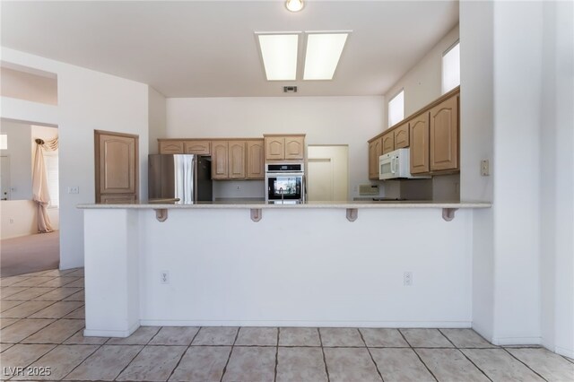 9812 Folsom Dr, Las Vegas, NV 89134 - kitchen featuring appliances with stainless steel finishes, a kitchen breakfast bar, a peninsula, and light countertops
