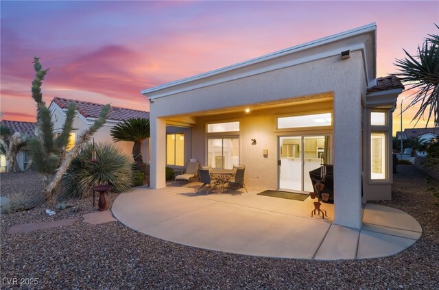 9812 Folsom Dr, Las Vegas, NV 89134 - back of house at dusk with a patio and stucco siding