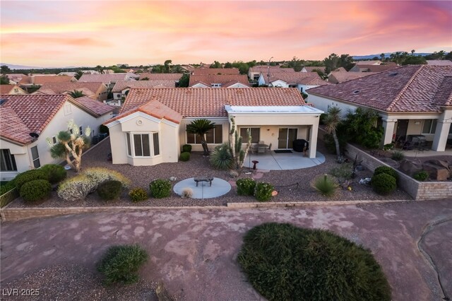 9812 Folsom Dr, Las Vegas, NV 89134 - back of property at dusk featuring a patio area, a tiled roof, stucco siding, and a residential view