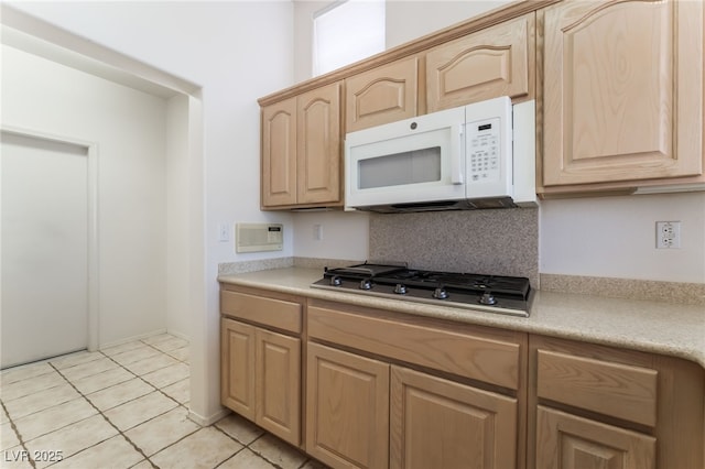 9812 Folsom Dr, Las Vegas, NV 89134 - kitchen featuring white microwave, light brown cabinetry, stainless steel gas cooktop, and light countertops