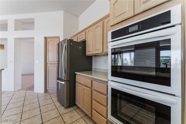 9812 Folsom Dr, Las Vegas, NV 89134 - kitchen with light brown cabinets, white double oven, freestanding refrigerator, light countertops, and light tile patterned floors