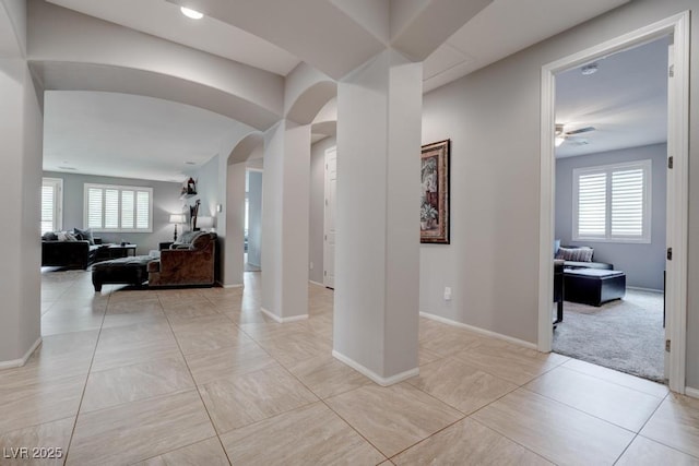 6985 Hopi Summit Ct, Las Vegas, NV 89149 - corridor featuring arched walkways, healthy amount of natural light, baseboards, and light tile patterned flooring