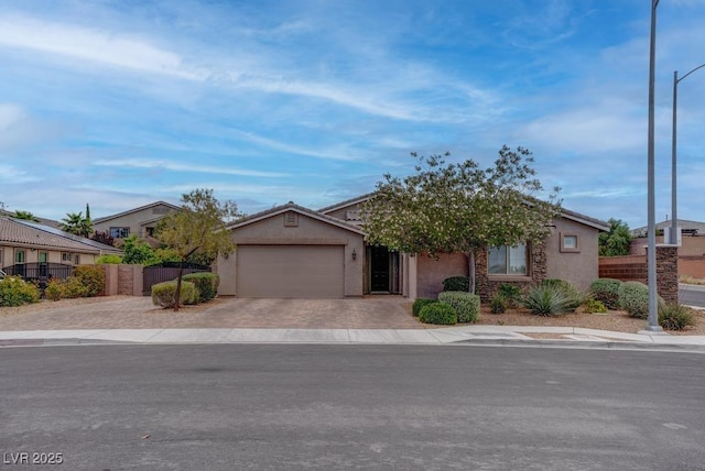 6985 Hopi Summit Ct, Las Vegas, NV 89149 - view of property hidden behind natural elements featuring decorative driveway, an attached garage, and stucco siding