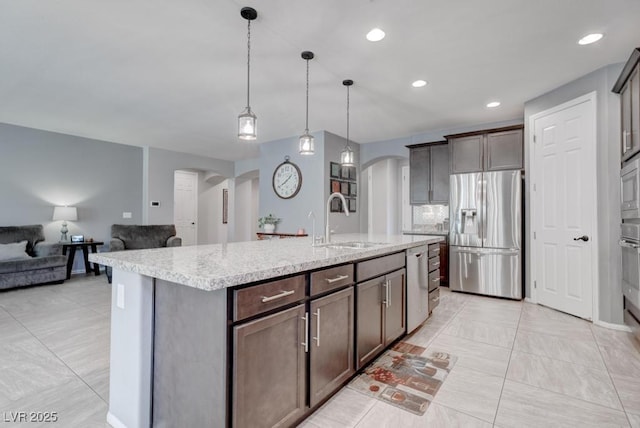 6985 Hopi Summit Ct, Las Vegas, NV 89149 - kitchen featuring appliances with stainless steel finishes, arched walkways, a sink, dark brown cabinetry, and recessed lighting