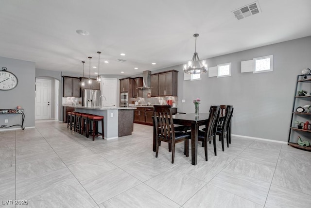 6985 Hopi Summit Ct, Las Vegas, NV 89149 - dining space featuring arched walkways, a chandelier, baseboards, and recessed lighting