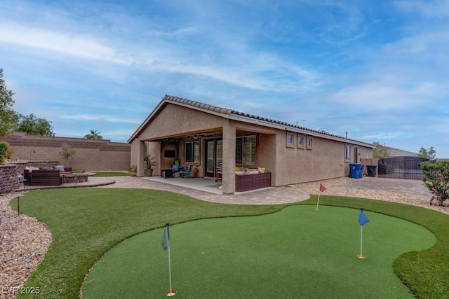 6985 Hopi Summit Ct, Las Vegas, NV 89149 - rear view of property with a patio area, a putting area, and a fenced backyard