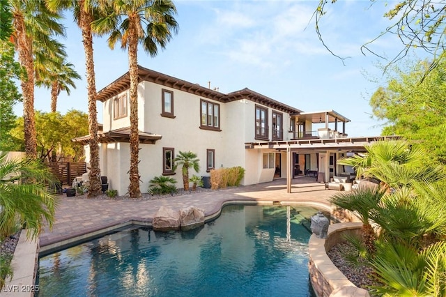 10301 Orkiney Dr, Las Vegas, NV 89144 - back of property featuring a balcony, a patio, stucco siding, and a pool with connected hot tub