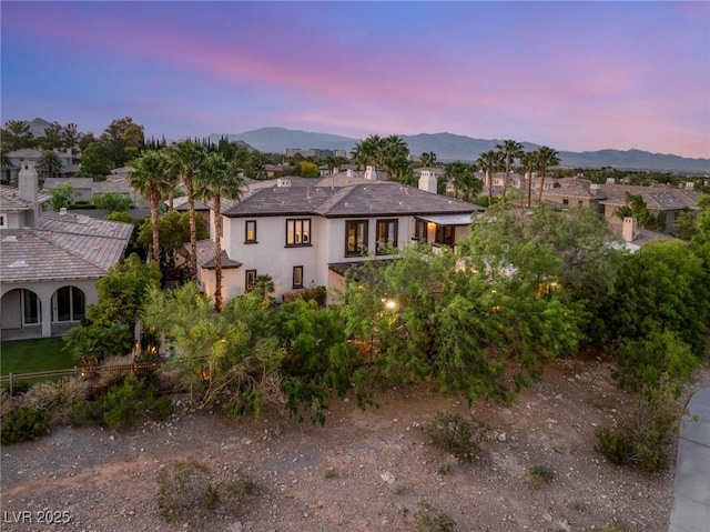 10301 Orkiney Dr, Las Vegas, NV 89144 - view of front of home with a mountain view, a chimney, stucco siding, and a residential view