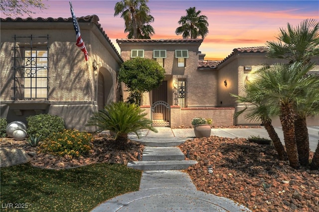7206 Laramie Ave, Las Vegas, NV 89113 - mediterranean / spanish-style house featuring a tile roof, stucco siding, a fenced front yard, and a gate