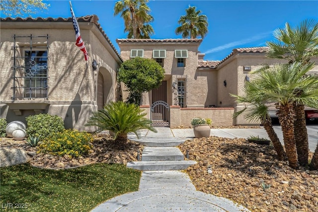 7206 Laramie Ave, Las Vegas, NV 89113 - mediterranean / spanish home featuring a tiled roof, stucco siding, a fenced front yard, and a gate