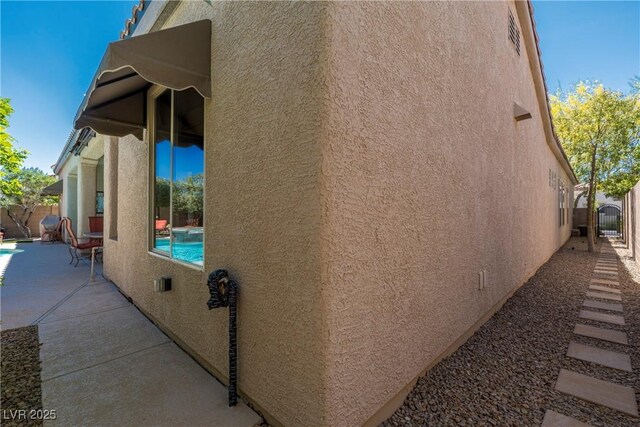 7206 Laramie Ave, Las Vegas, NV 89113 - view of side of property with stucco siding and a patio