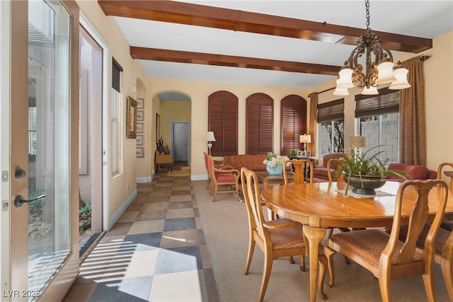 7206 Laramie Ave, Las Vegas, NV 89113 - dining space featuring a chandelier, beamed ceiling, arched walkways, baseboards, and light flooring
