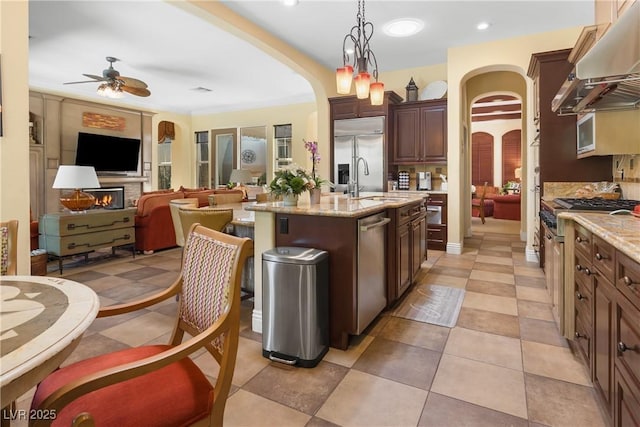 7206 Laramie Ave, Las Vegas, NV 89113 - kitchen featuring arched walkways, under cabinet range hood, a ceiling fan, stainless steel appliances, and open floor plan