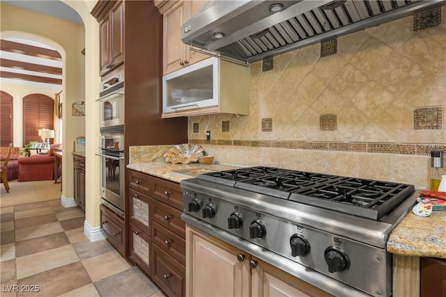 7206 Laramie Ave, Las Vegas, NV 89113 - kitchen with stainless steel gas cooktop, arched walkways, ventilation hood, tasteful backsplash, and beam ceiling