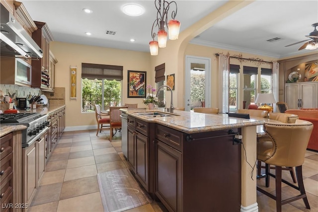 7206 Laramie Ave, Las Vegas, NV 89113 - kitchen featuring stainless steel appliances, under cabinet range hood, a sink, arched walkways, and a breakfast bar