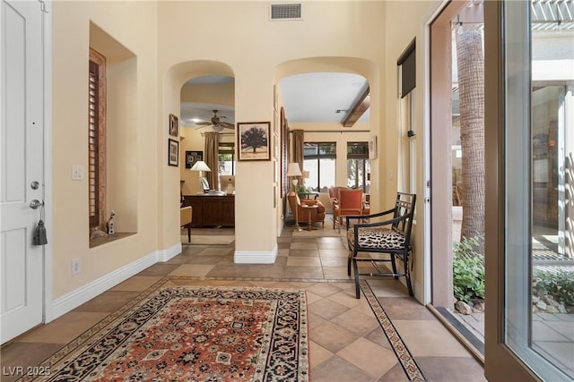 7206 Laramie Ave, Las Vegas, NV 89113 - foyer entrance with arched walkways, ceiling fan, baseboards, tile patterned floors, and inlaid floor details