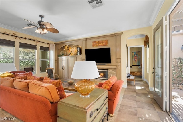 7206 Laramie Ave, Las Vegas, NV 89113 - living room featuring ceiling fan, ornamental molding, a fireplace, and arched walkways