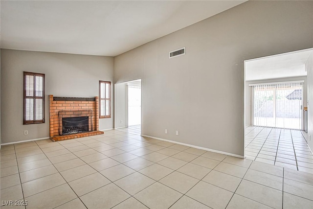 3596 Bronco Rd, Las Vegas, NV 89103 - unfurnished living room with light tile patterned floors, a fireplace, baseboards, and a high ceiling