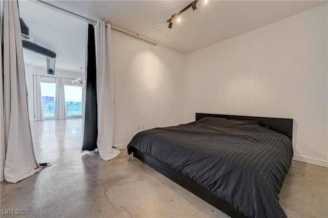 200 Hoover Ave Unit 1905, Las Vegas, NV 89101 - bedroom with concrete flooring, track lighting, baseboards, and a chandelier