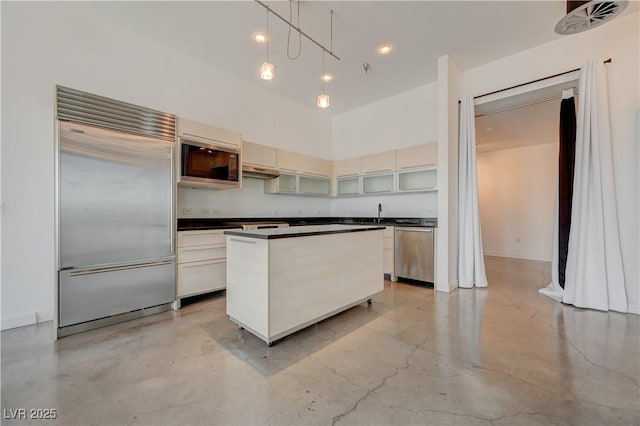 200 Hoover Ave Unit 1905, Las Vegas, NV 89101 - kitchen featuring built in appliances, dark countertops, a center island, concrete flooring, and a high ceiling