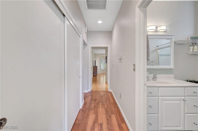 2805 Hanging Rock Dr, Las Vegas, NV 89134 - hall with a sink, light wood-style flooring, baseboards, and recessed lighting