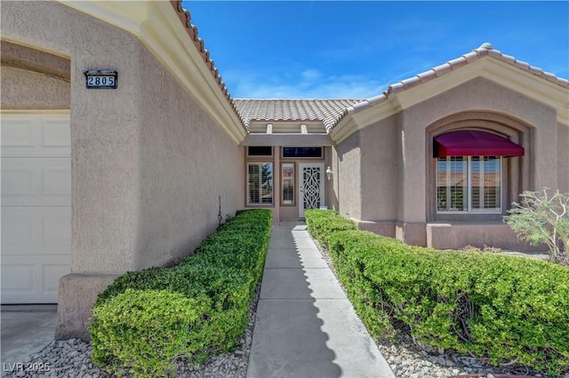 2805 Hanging Rock Dr, Las Vegas, NV 89134 - property entrance featuring an attached garage, stucco siding, and a tile roof