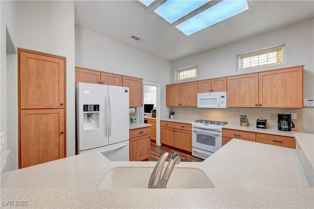 2805 Hanging Rock Dr, Las Vegas, NV 89134 - kitchen with white appliances, a sink, light countertops, and dark wood finished floors
