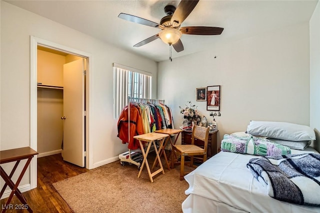 4832 Englewood Ave, Las Vegas, NV 89139 - bedroom with a spacious closet, baseboards, wood finished floors, ceiling fan, and a closet