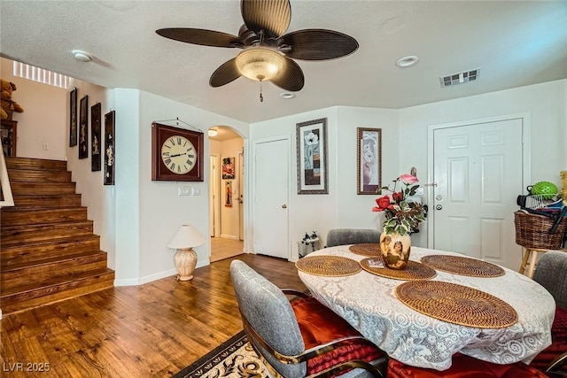 4832 Englewood Ave, Las Vegas, NV 89139 - dining space featuring arched walkways, wood finished floors, stairs, ceiling fan, and baseboards