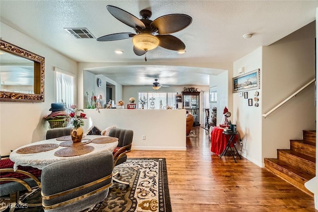 4832 Englewood Ave, Las Vegas, NV 89139 - dining area featuring ceiling fan, wood finished floors, stairs, and a textured ceiling