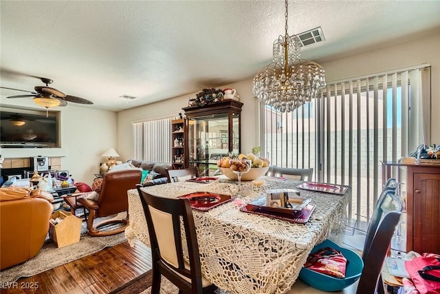 4832 Englewood Ave, Las Vegas, NV 89139 - dining space with wood finished floors, a textured ceiling, a chandelier, and a ceiling fan
