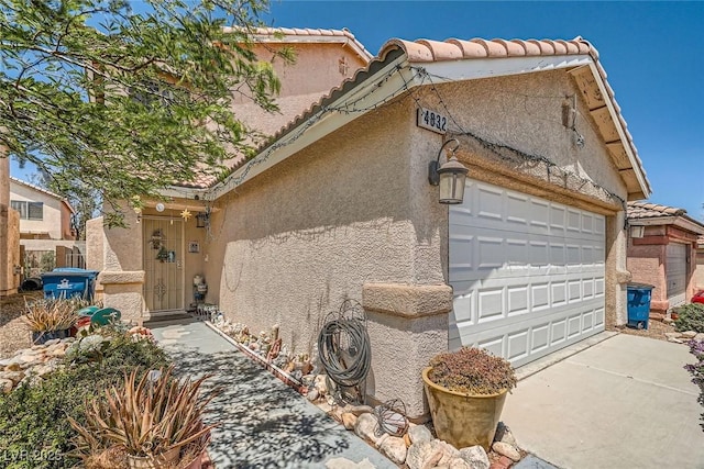 4832 Englewood Ave, Las Vegas, NV 89139 - view of front of home featuring stucco siding, driveway, a tile roof, and a garage